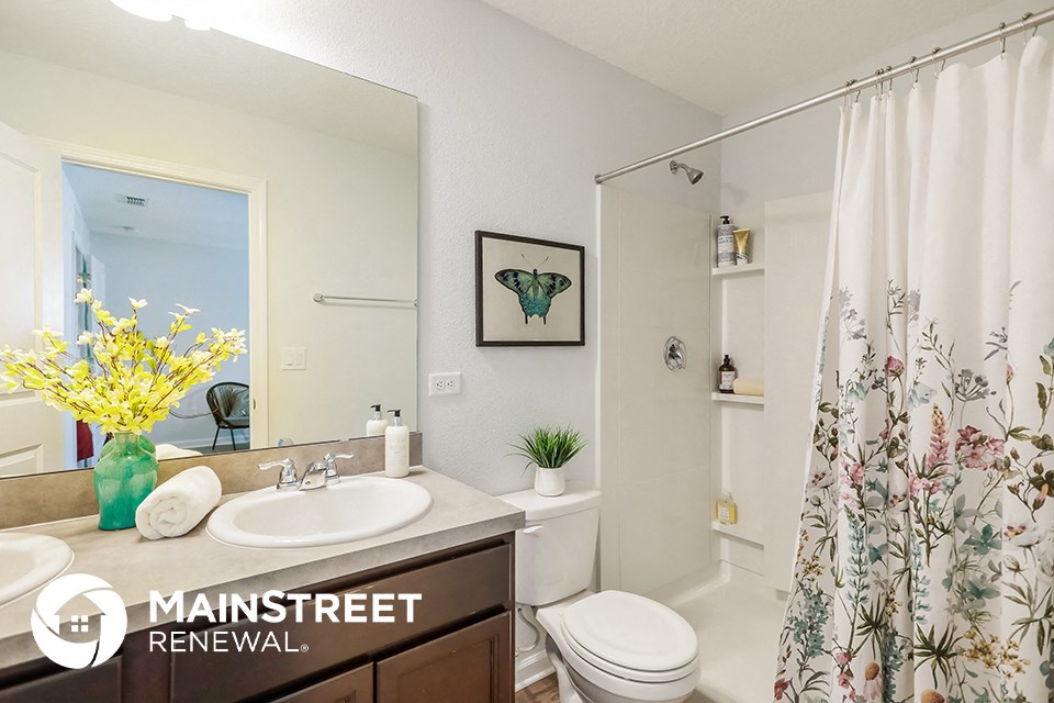 a bathroom with a shower curtain and a sink and a toilet