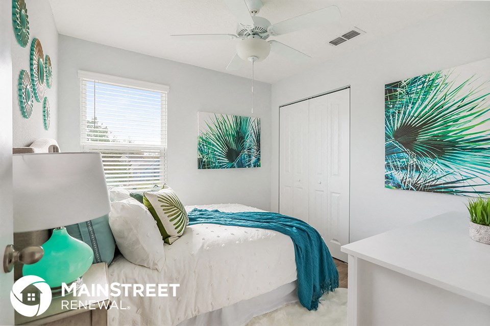 a bedroom with a bed and a ceiling fan