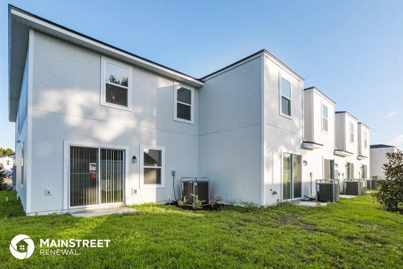 a row of white houses with grass in front of them
