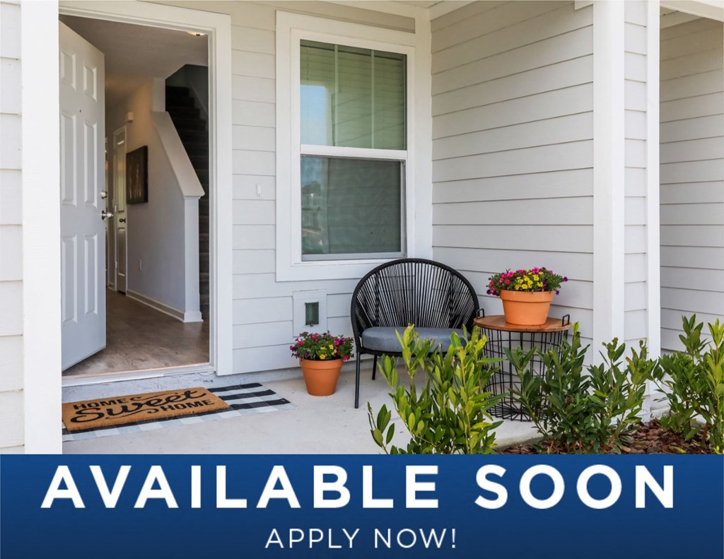 a small porch with a chair and plants on the side of a house