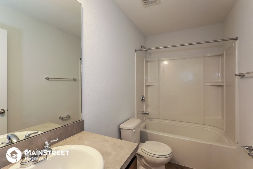 a white bathroom with a shower toilet and sink