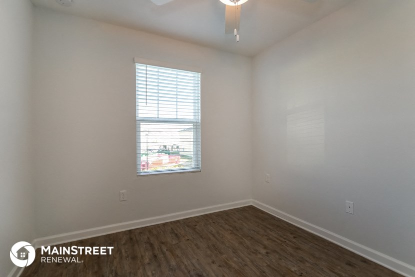 the interior of an empty room with wooden floors and a window