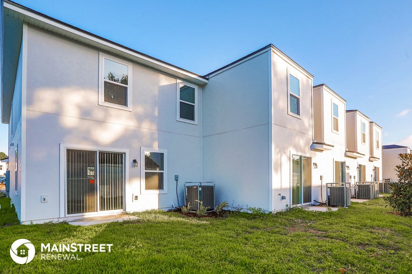 a group of white houses with grass in front of them