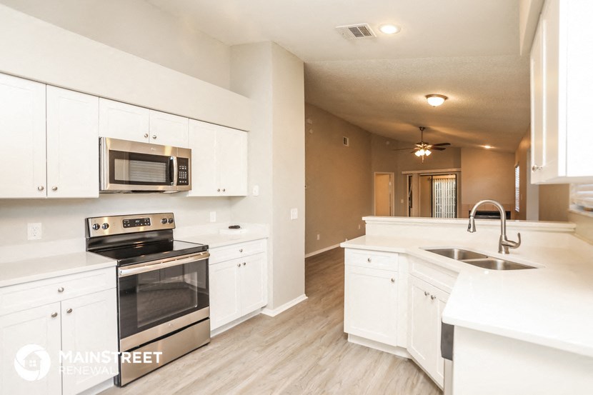 a kitchen with white cabinets and stainless steel appliances