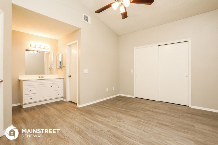the master bedroom has a large closet and a sink and a mirror