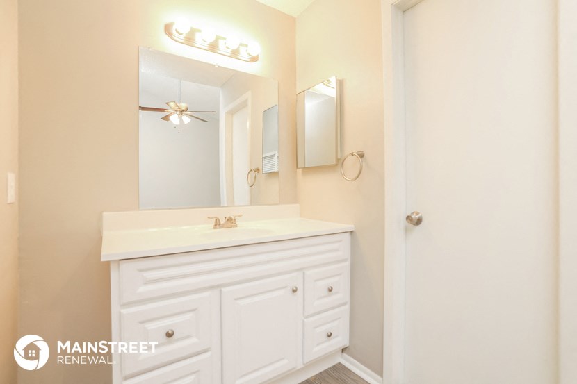 a white bathroom with a sink and a mirror