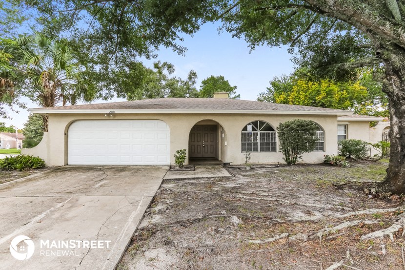 a white house with a garage and trees
