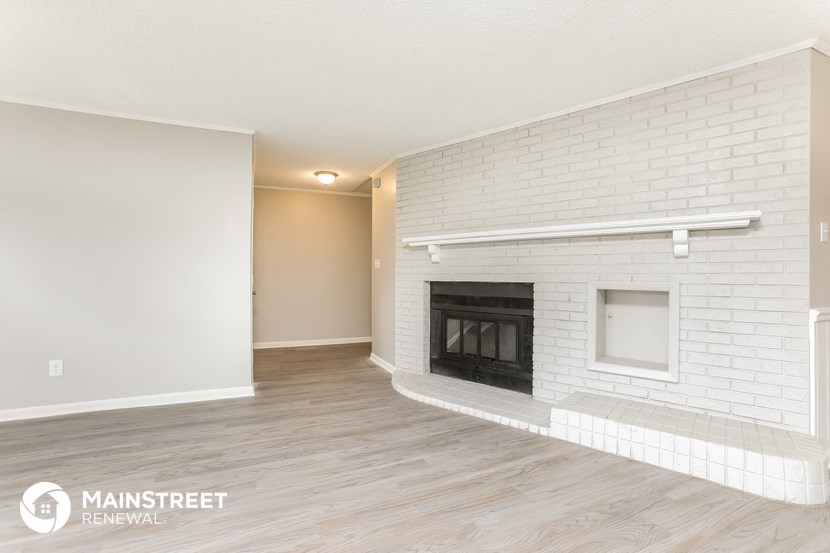 the living room of an apartment with a fireplace