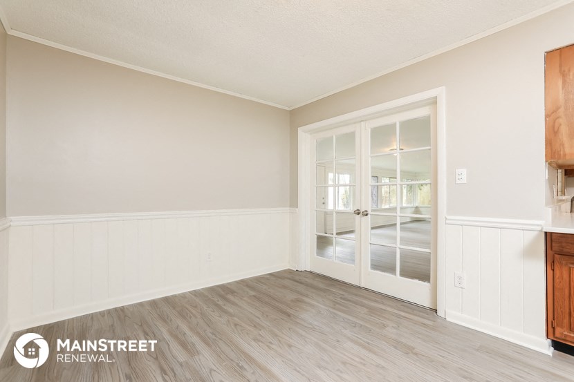 a living room with a door to a kitchen