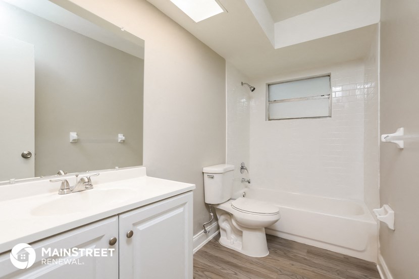 a bathroom with a toilet sink and tub and a mirror