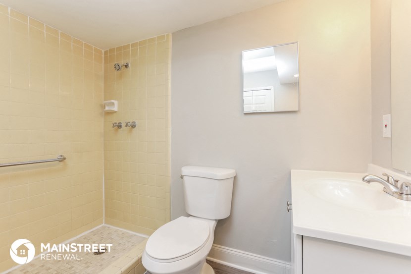 a bathroom with a toilet and a sink and a mirror