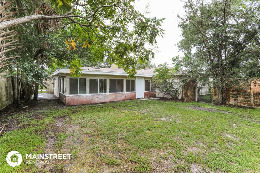 an old brick house with a yard and trees