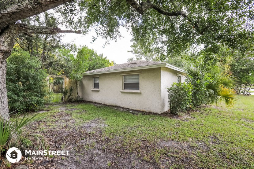 a small white house sitting under a tree