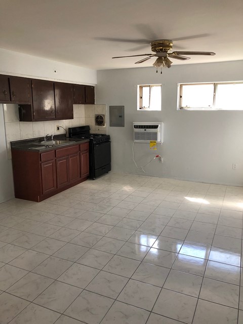 A kitchen with a fan and a counter.
