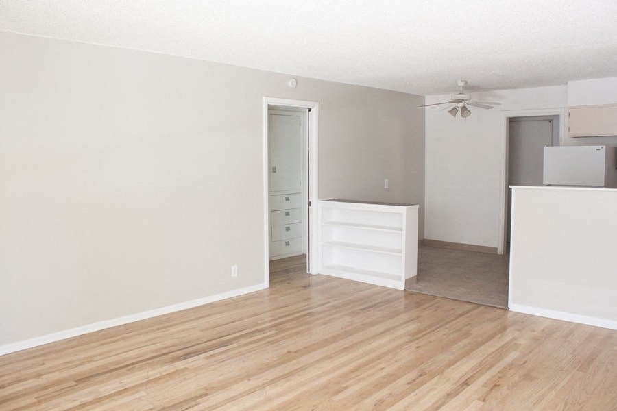 A room with a wooden floor and a ceiling fan.