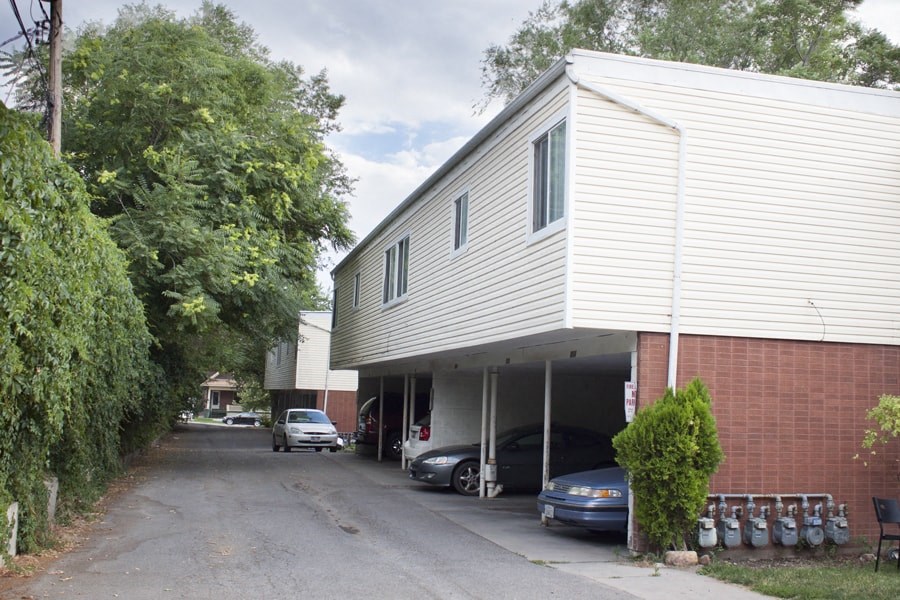 A long white garage with a car in the door.