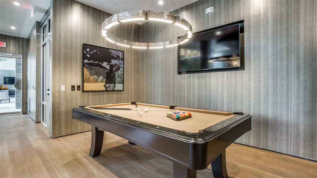 a pool table in a living room with a chandelier