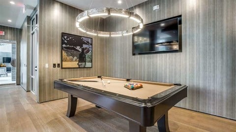 a pool table in a living room with a chandelier