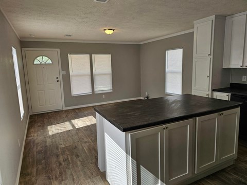 A kitchen with a black counter top and white cabinets.