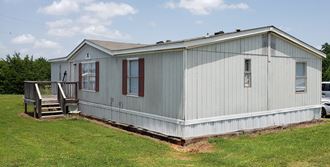 a manufactured home with a porch and a deck