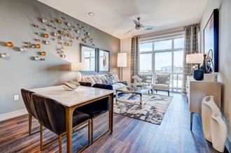 a living room with a dining room table and a large window
