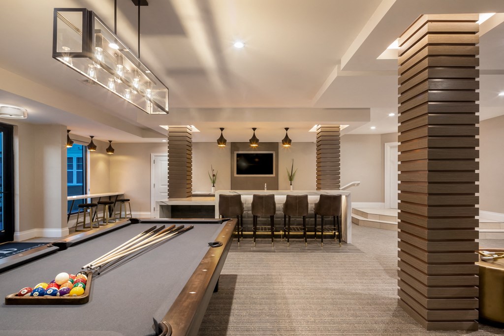 a game room with a pool table and a bar