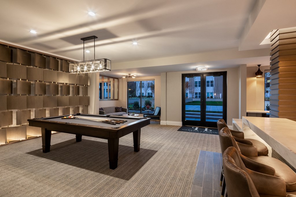 a large game room with a pool table and a bar