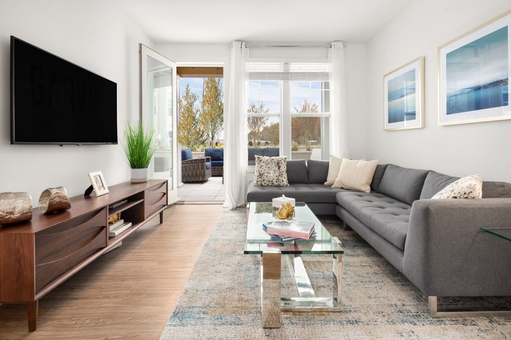 a living room with a gray couch and a glass coffee table