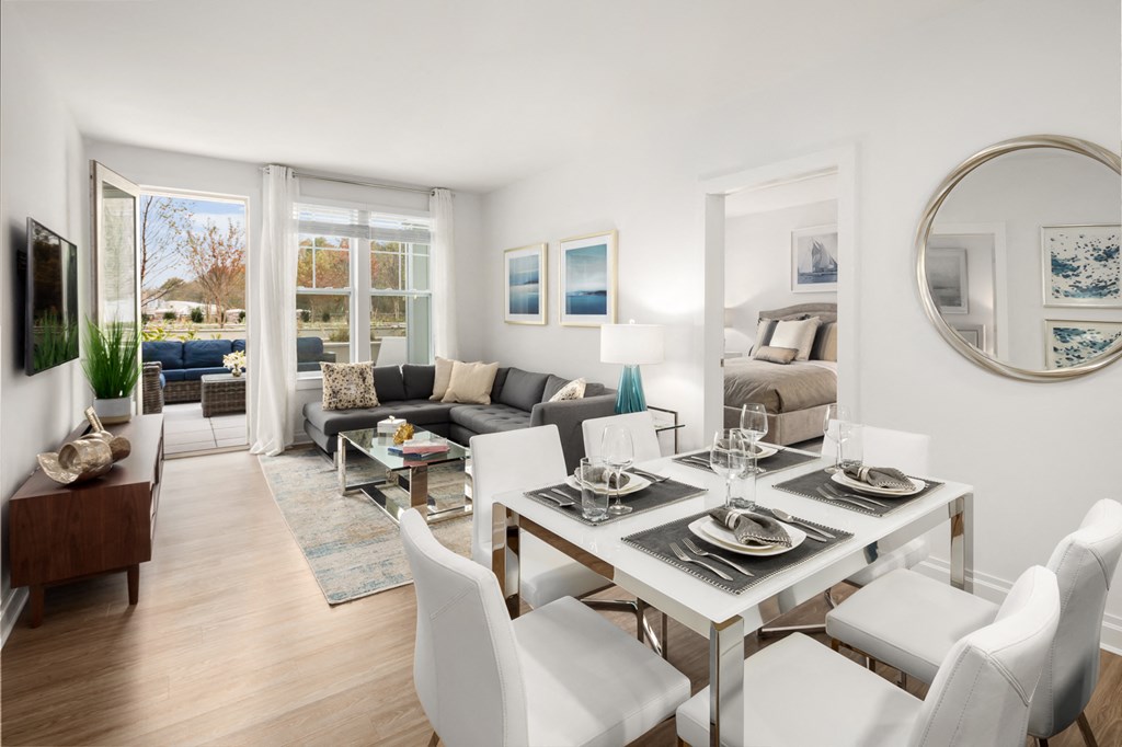 a living room and dining room with a table and chairs