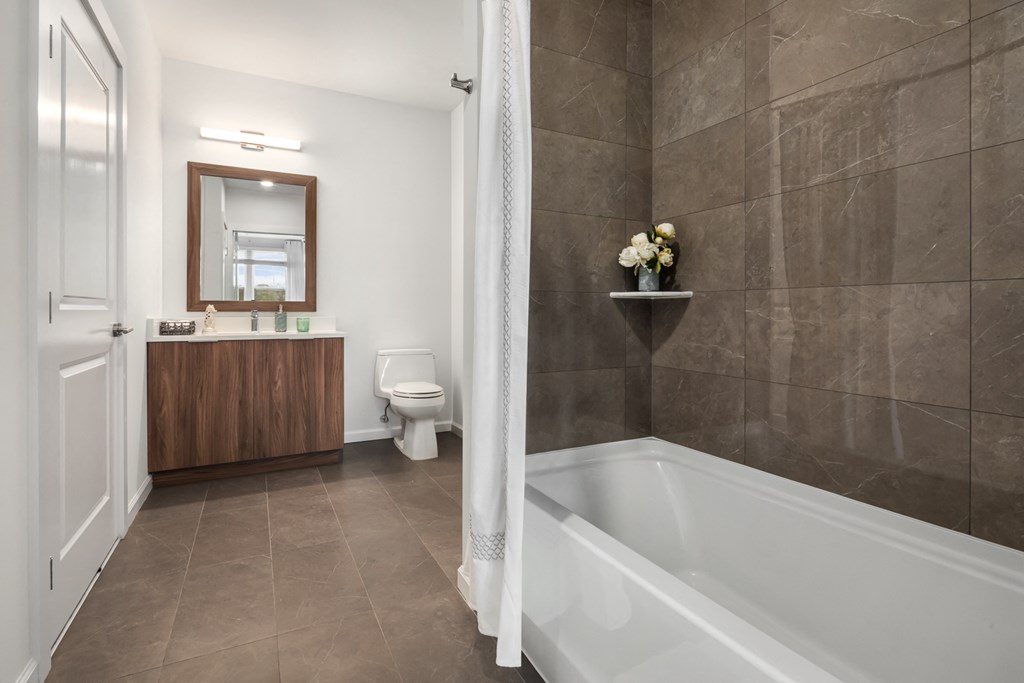 a bathroom with a tub and a sink and a toilet