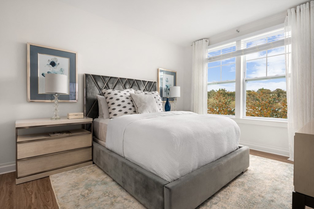 a bedroom with a bed and two windows