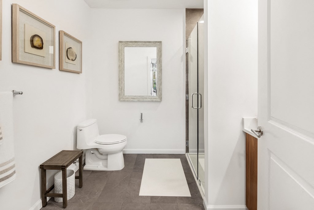 a white bathroom with a toilet and a shower