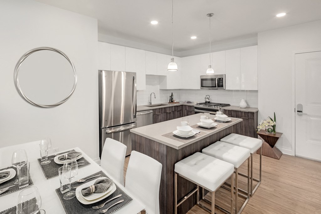 a kitchen and dining area with a stainless steel refrigerator