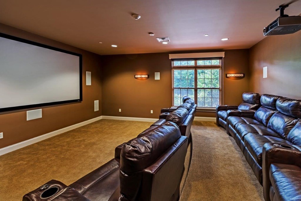 a large living room with leather couches and a television