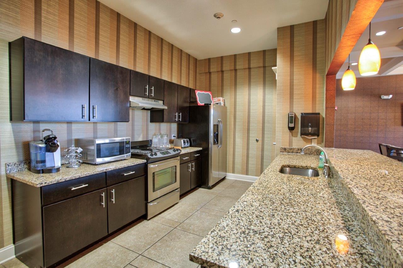 a large kitchen with granite counter tops and stainless steel appliances