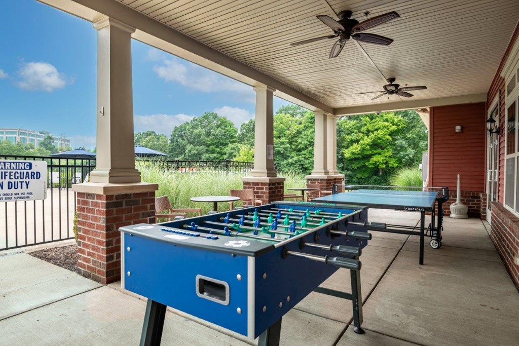 a covered patio with a foosball table and a ping pong table