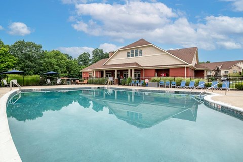 a swimming pool with a house in the background