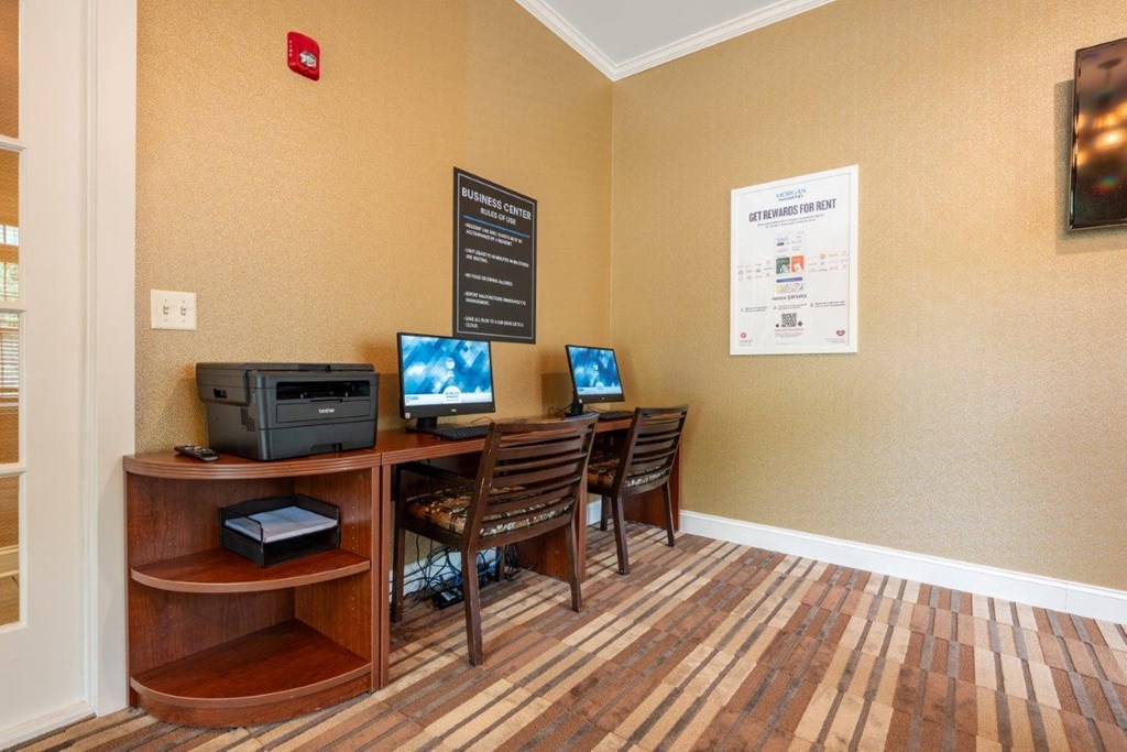 a home office with a desk with two computers and a printer