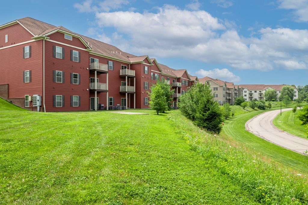 an apartment building with a green yard in front of it