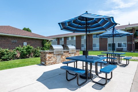 our picnic table with umbrellas in front of our building