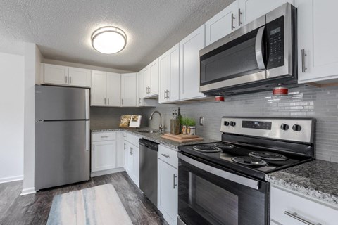 a kitchen with stainless steel appliances and white cabinets