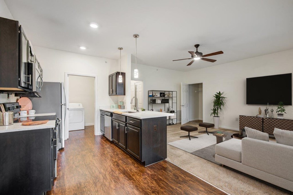 a living room and kitchen with a couch and a tv