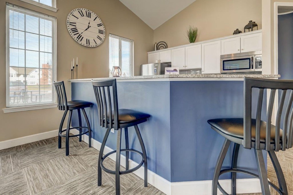 a kitchen with a counter and three stools