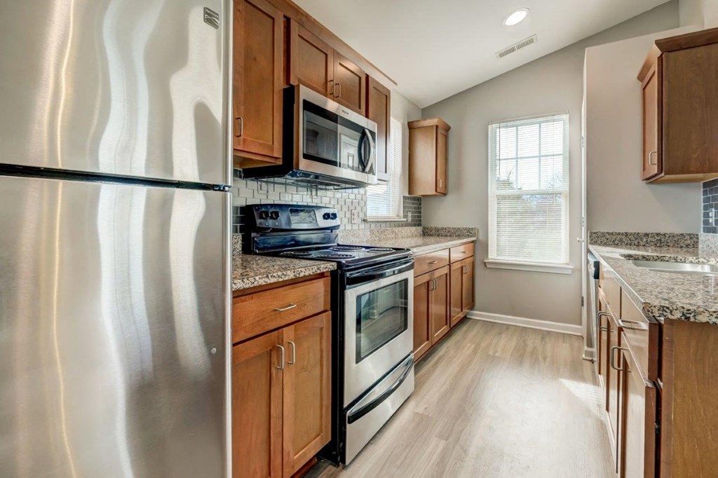a kitchen with stainless steel appliances and wooden cabinets