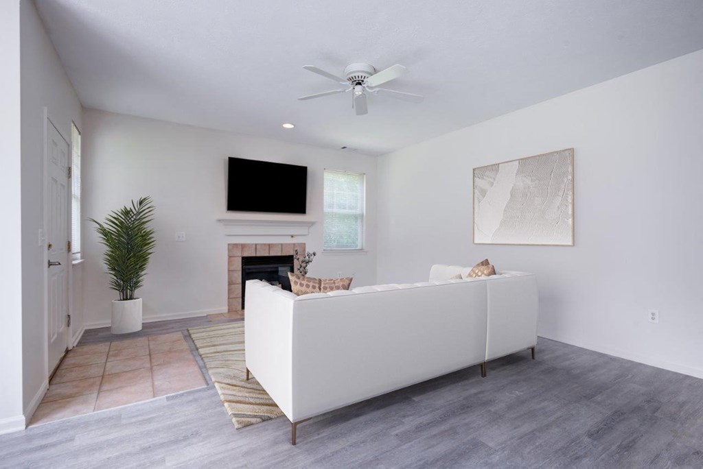 a living room with a white couch and a ceiling fan