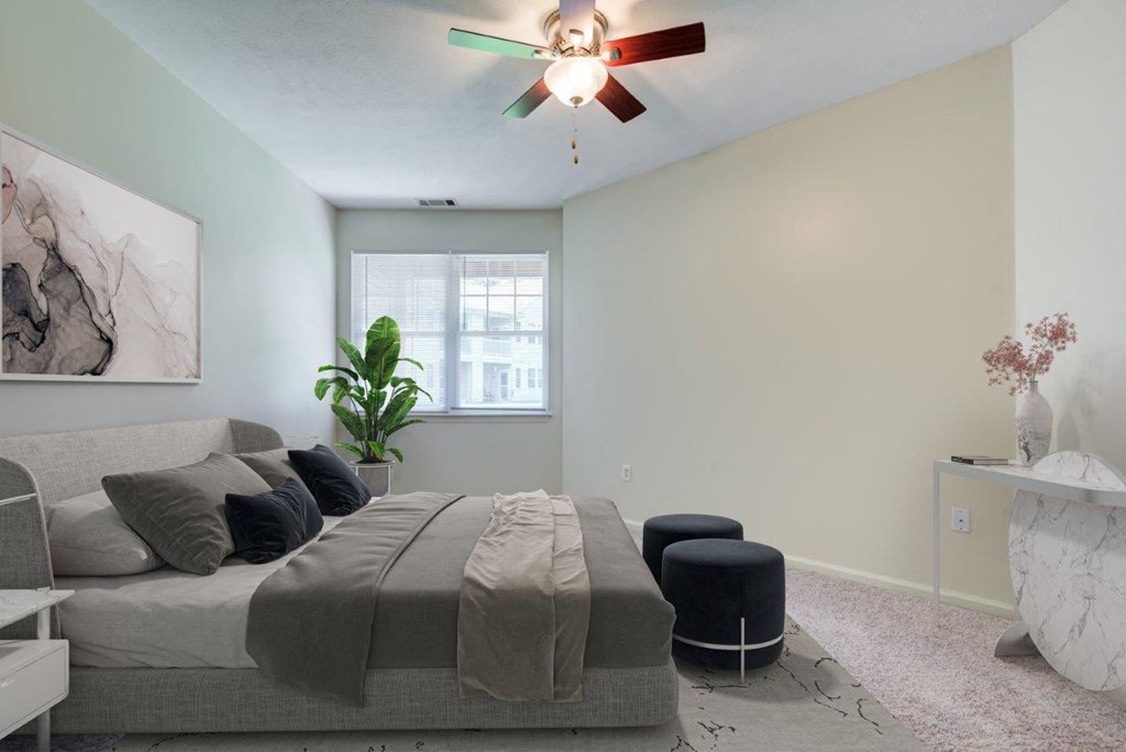 a bedroom with a bed and a ceiling fan