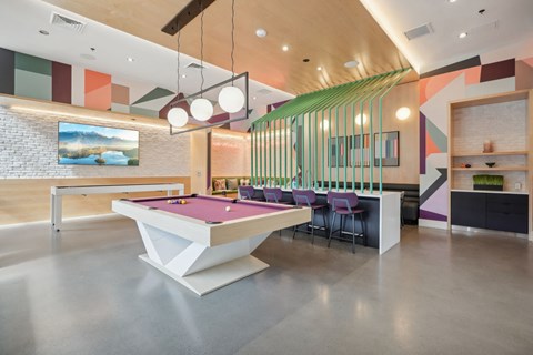 a billiards table in a room with a bar