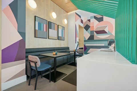 a restaurant with blue couches and tables and a colorful wall