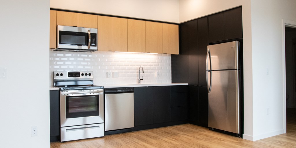 a kitchen with black and white appliances and a stainless steel refrigerator