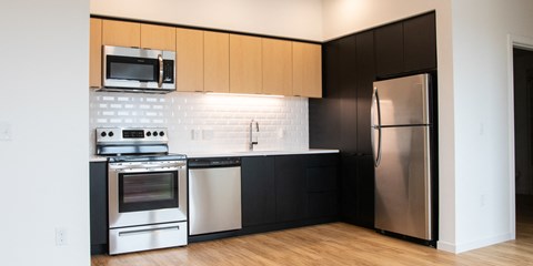 a kitchen with black and white appliances and a stainless steel refrigerator